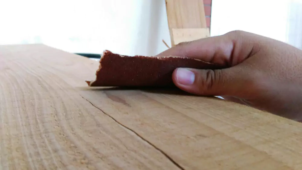 Pengampelasan permukaan kayu untuk memastikan hasil finishing yang lebih halus